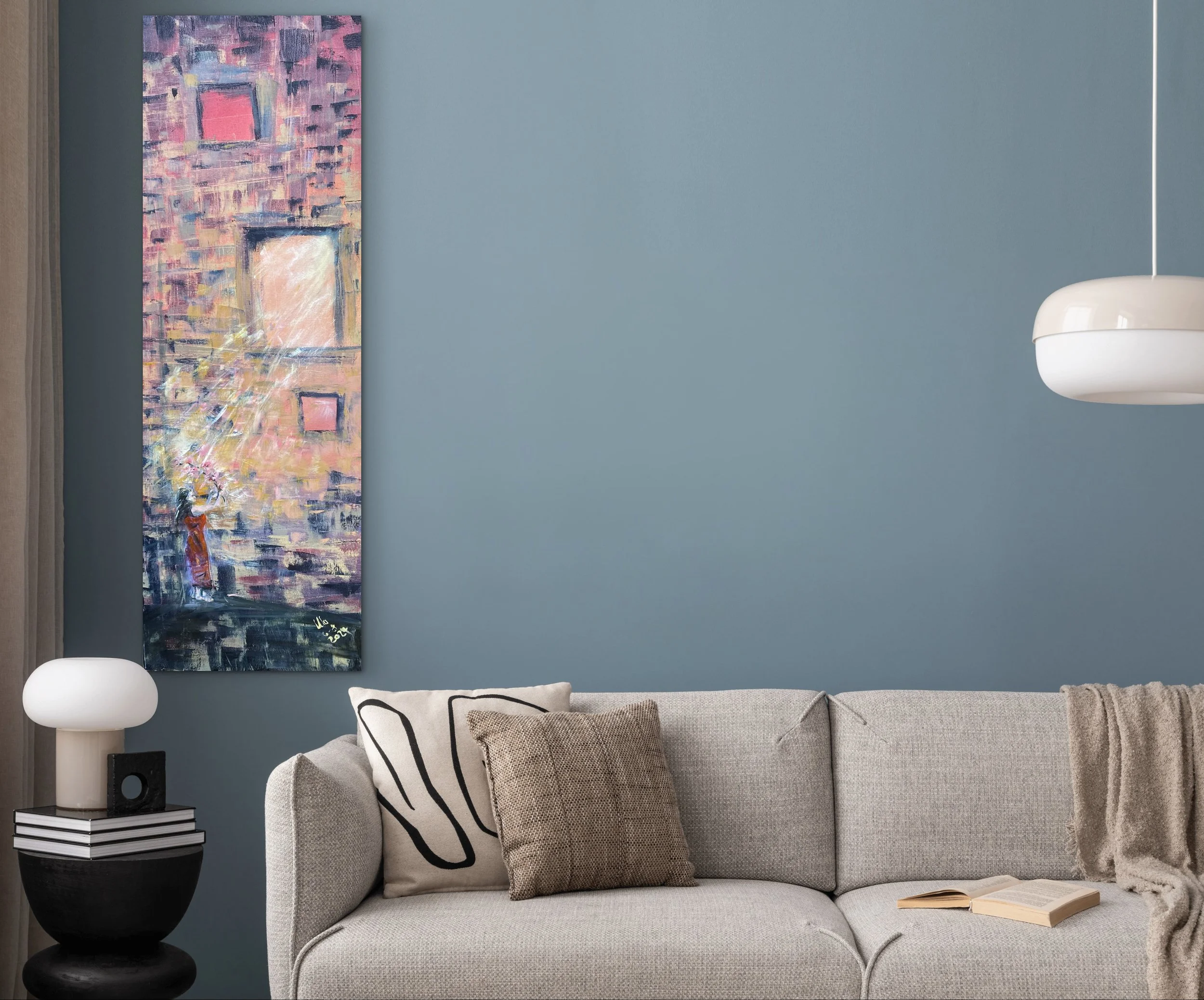 Innenraum Wohnzimmer mit blauer Wand, moderner abstrakter Wandkunst, beige Couch mit Kissen, Beistelltisch mit Lampe und Büchern, offene Zeitschrift auf der Couch.