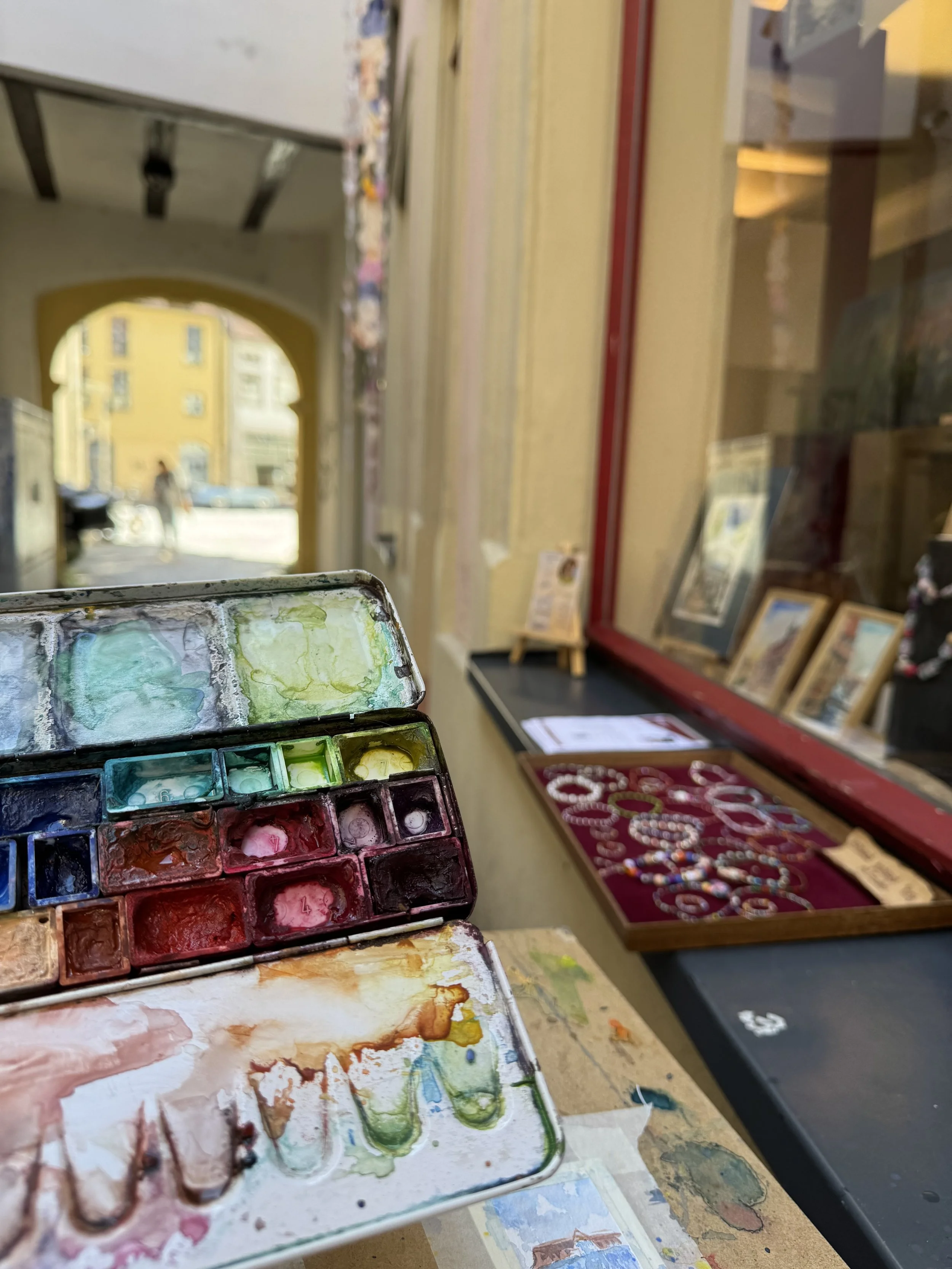 Aquarellkasten der Künstlerin vor der Galerie Spielraum in der Hasengasse in Bamberg, Hinweis auf das Arbeiten im öffentlichen Raum.