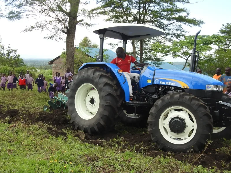 Tractor plowing a family field as part of the Life For Children Ministry crop assistance program