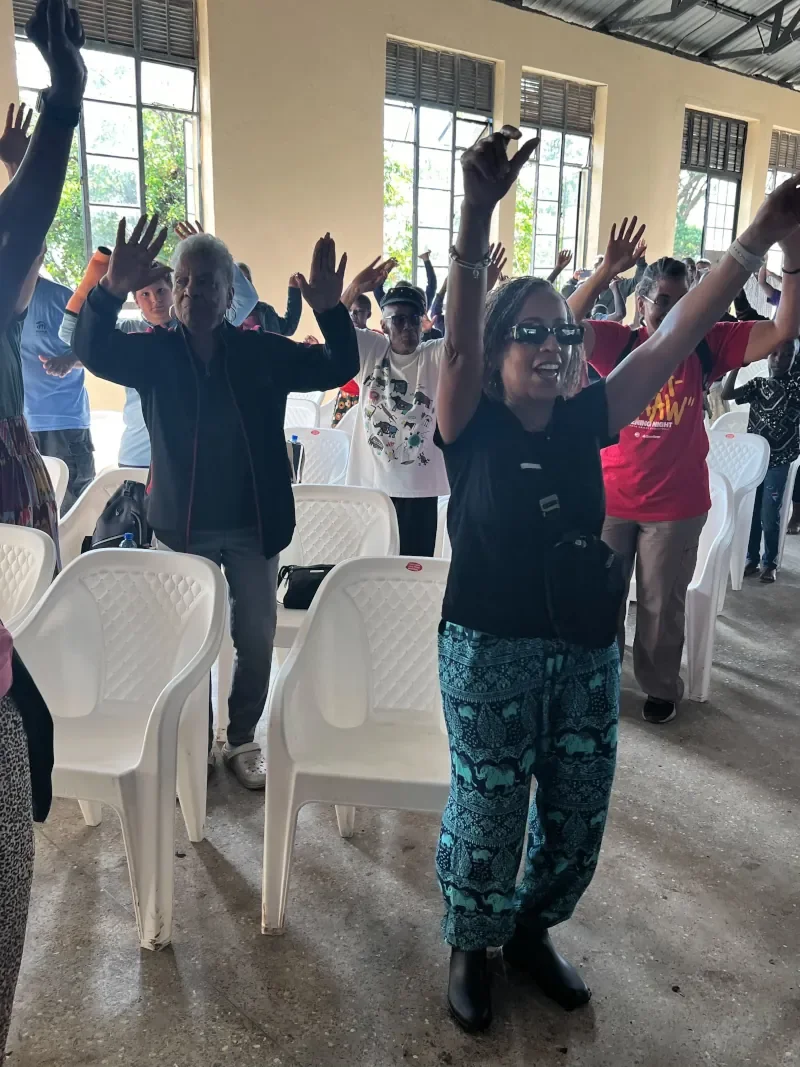 Children and mission volunteers raising hands in worship during a Life For Children Ministry gathering