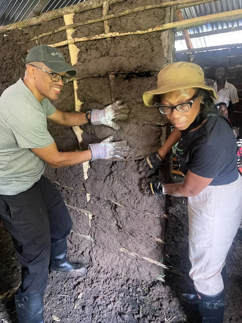 Mission volunteers applying mud plaster to walls of a widow's home under construction in Kenya