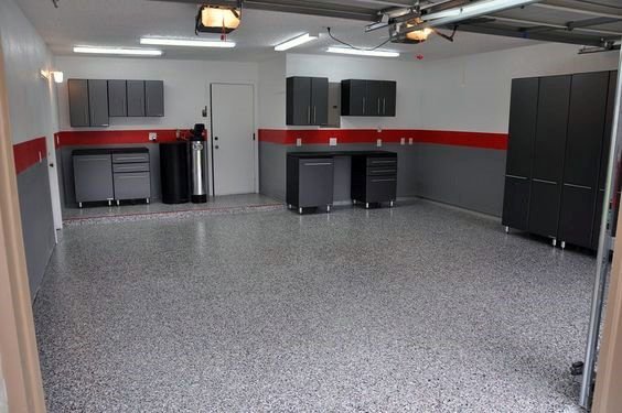 Clean and organized garage interior with storage cabinets, workbench, and epoxy flooring.