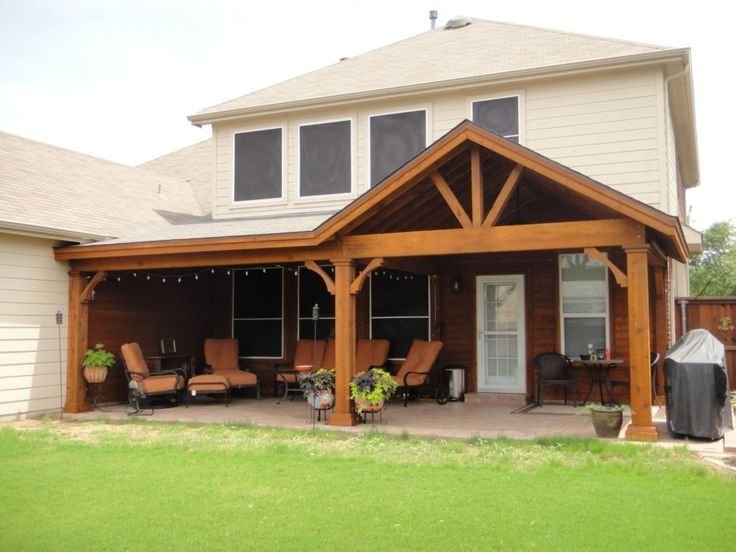 Backyard patio renovation with wooden pergola, outdoor furniture, and grill.