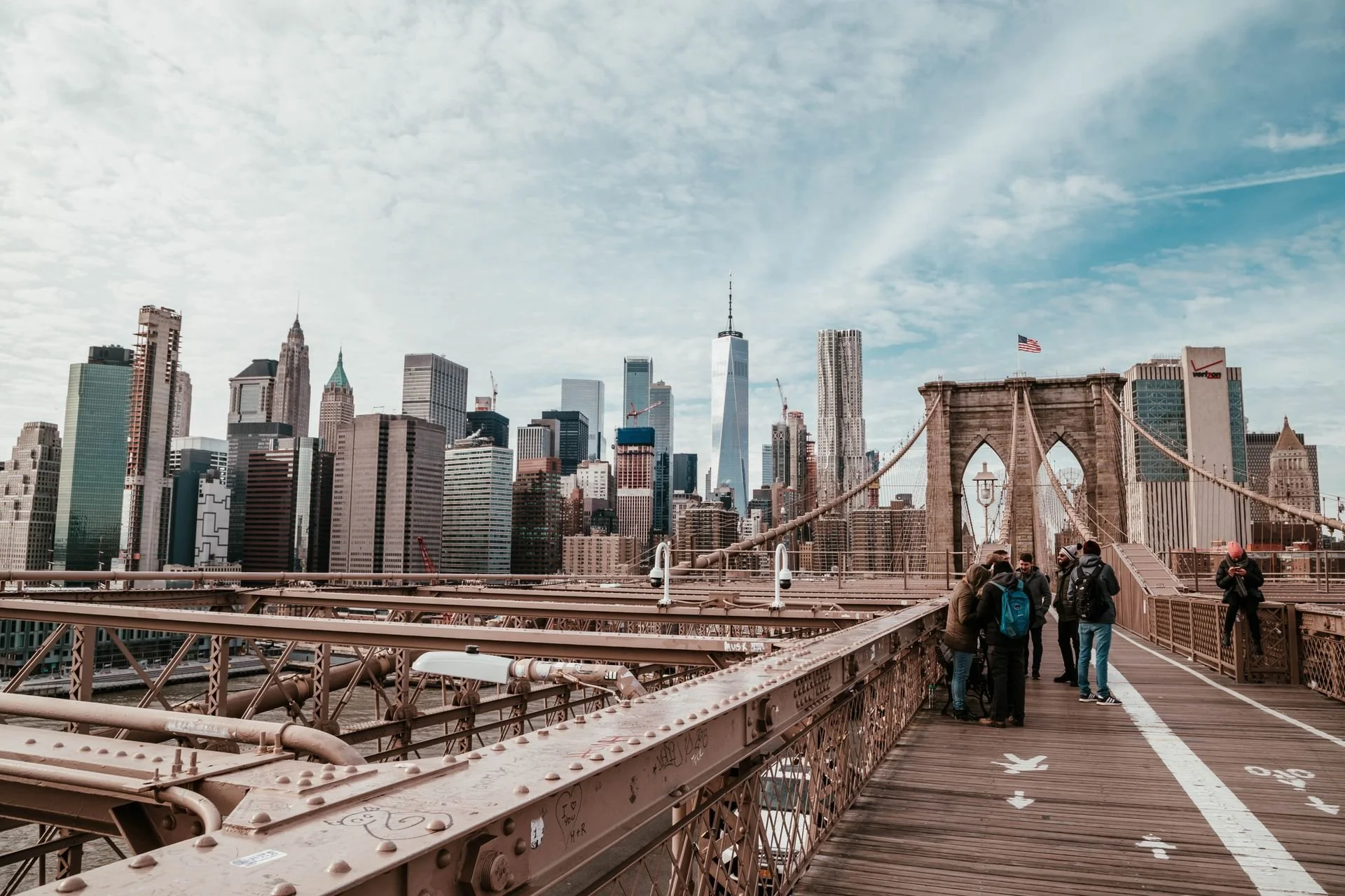 Tourists on the Brooklyn Bridge with the Manhattan skyline and One World Trade Center in the background, New York City