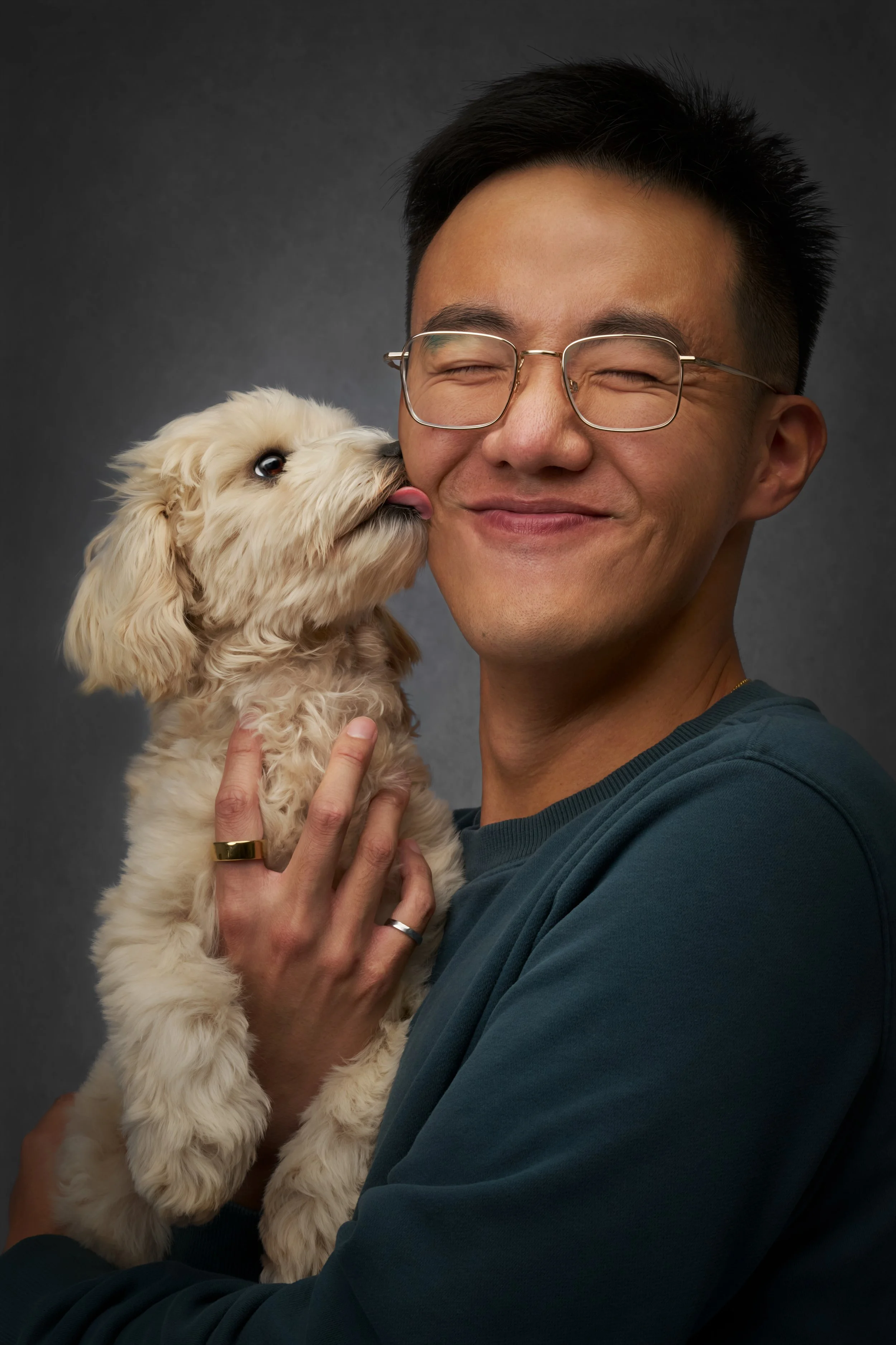 puppy pet photo of a dog licking his dog dad's face during their photo session in kirkland's photo studio