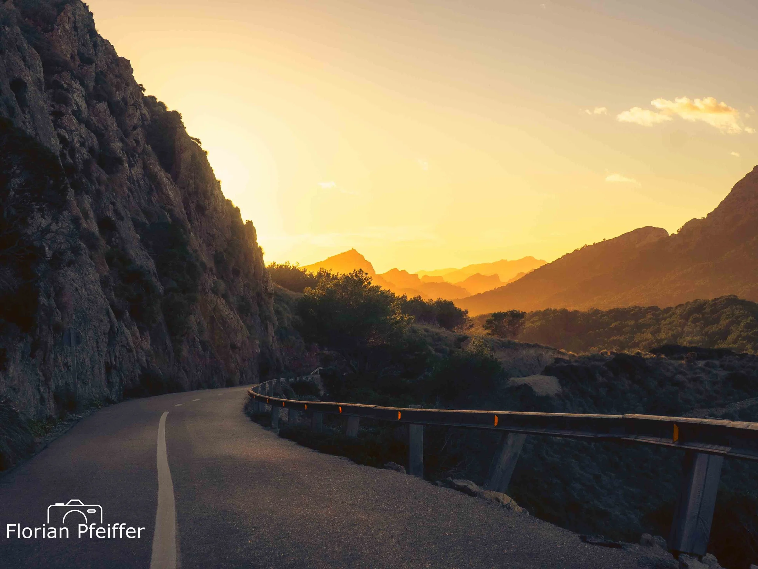 a mountain road during the last minutes of sunset in golden lighting 