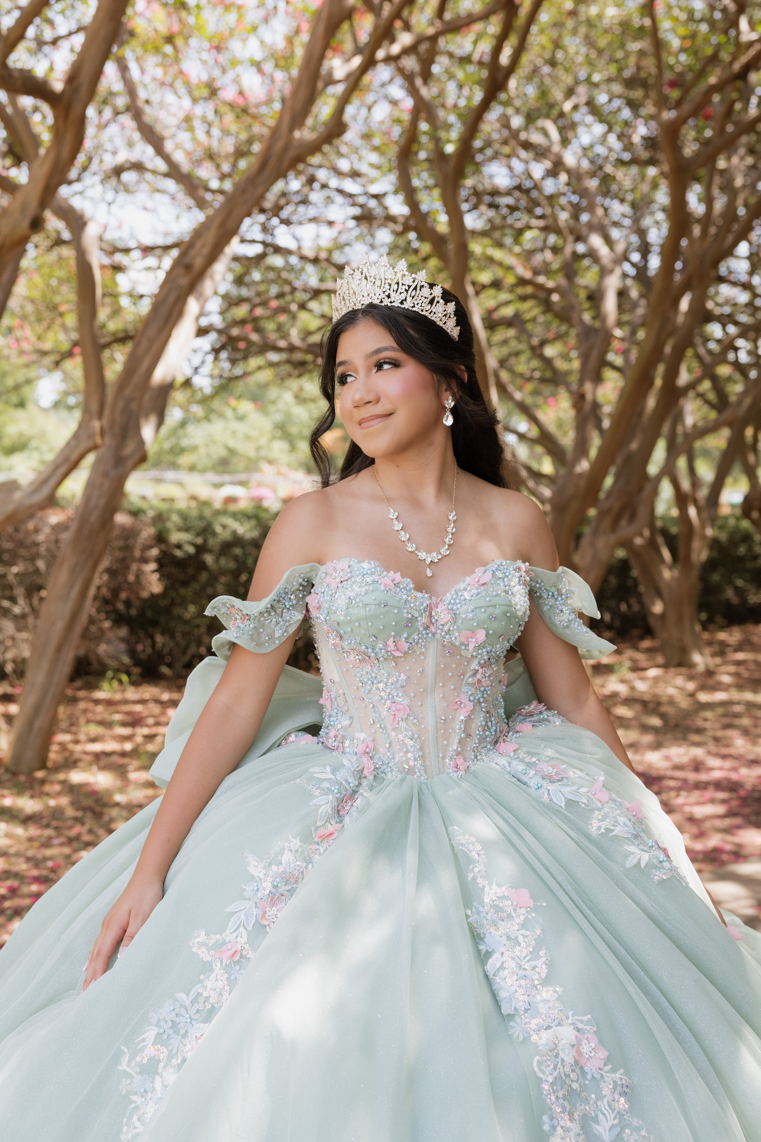 Quinceañera wearing a light blue floral gown during an outdoor portrait session in Dallas