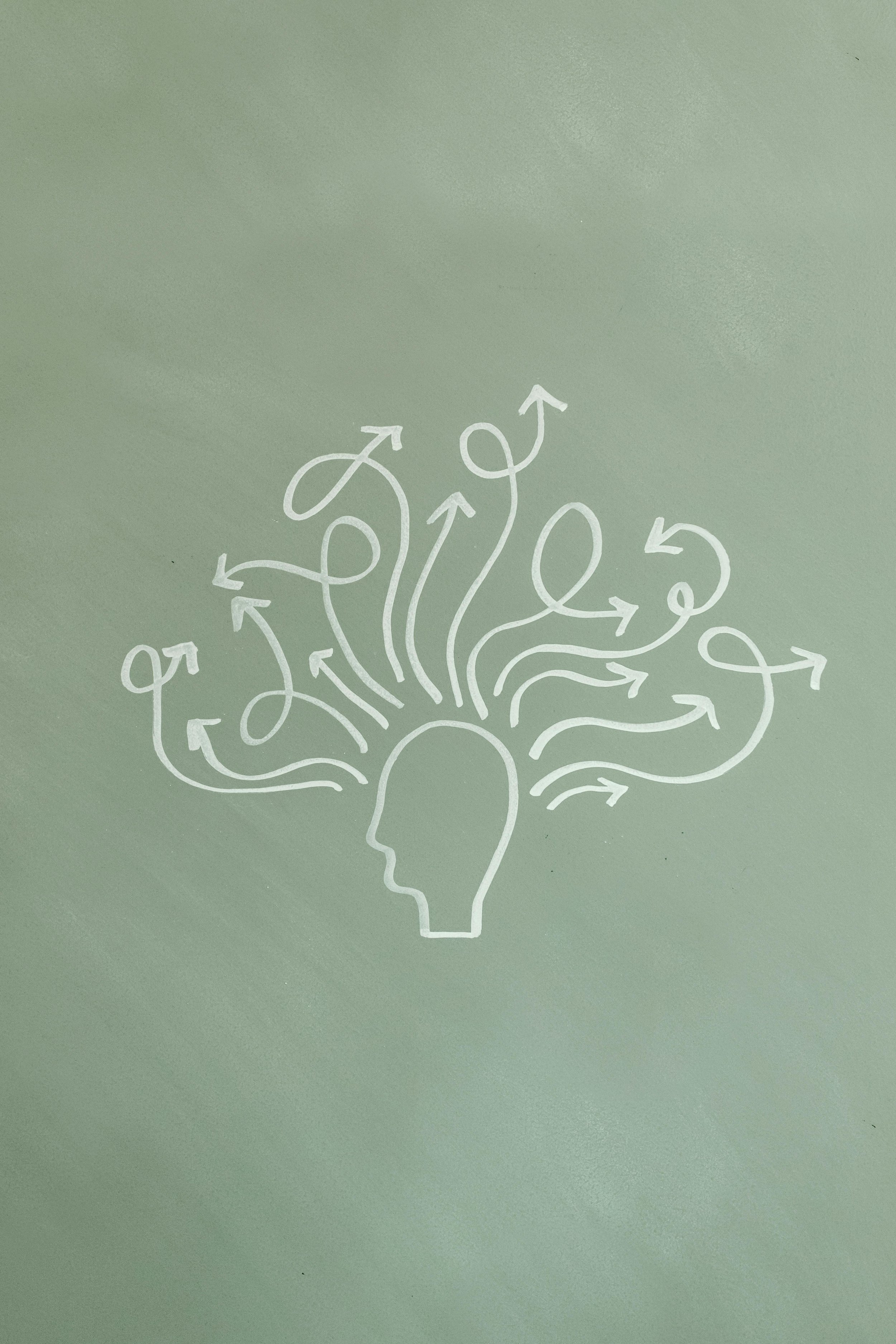 chalk board drawing of a head with a bunch of arrows coming out in different directions