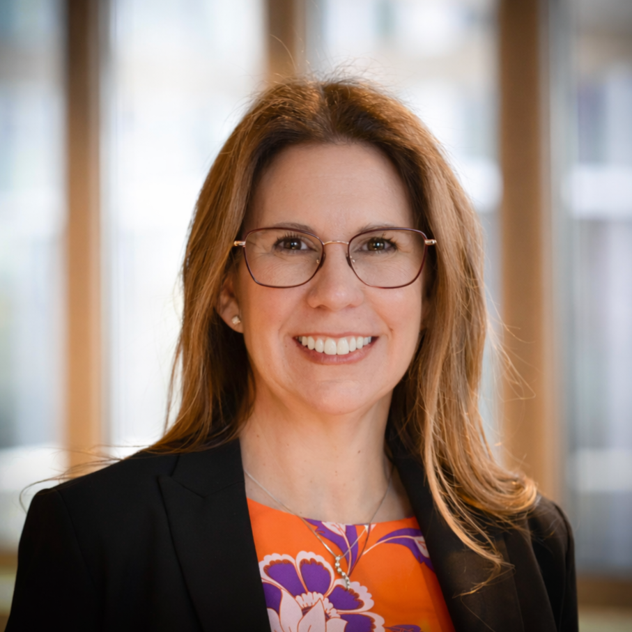 Rachel Dunpal, a logisitcs leader, standing indoors with a background of windows and natural light.