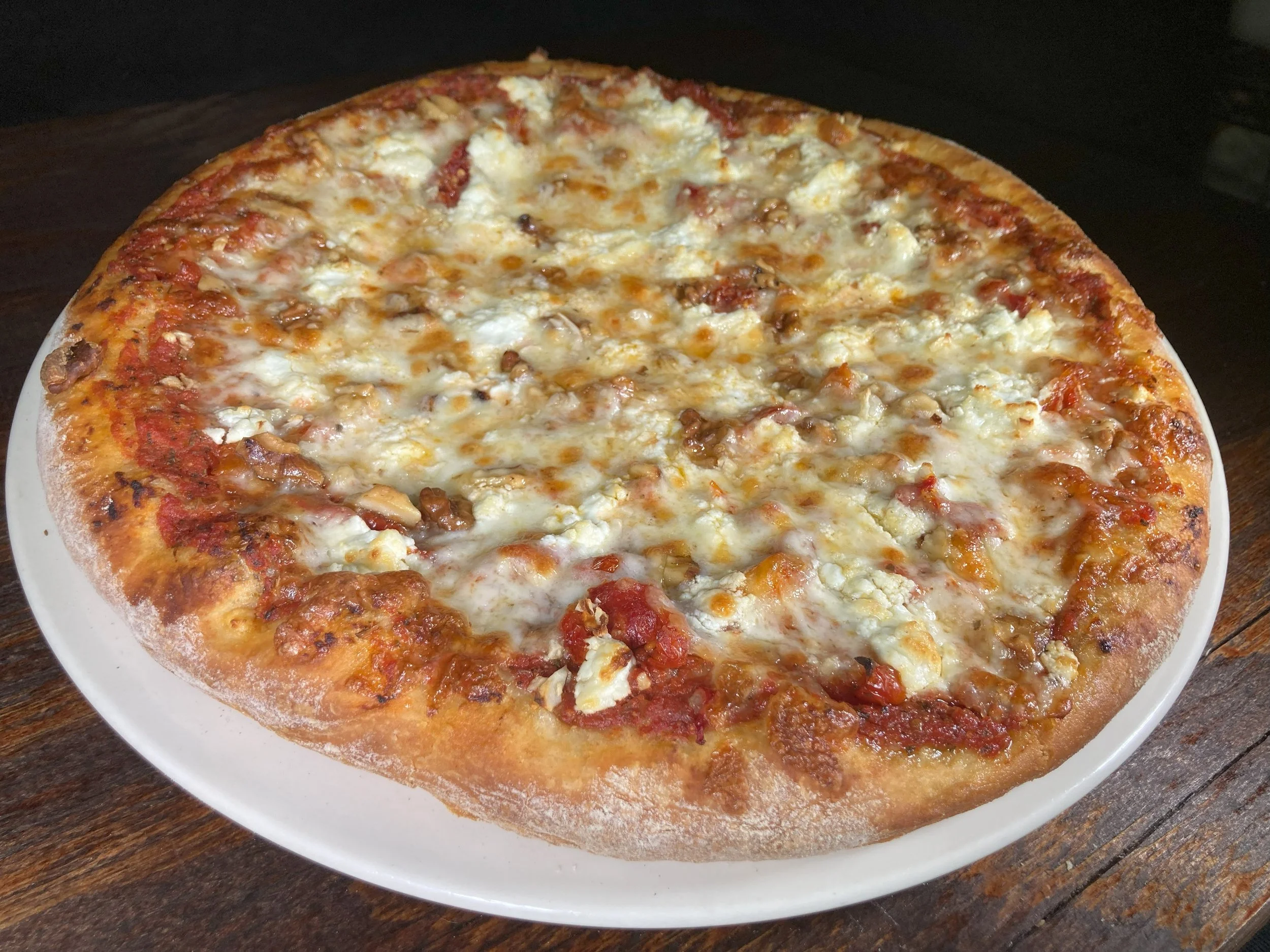 Plapo pizza from Bryn Mawr Pizza & Deli with sundried tomatoes, goat cheese, garlic, and walnuts on a golden thin crust