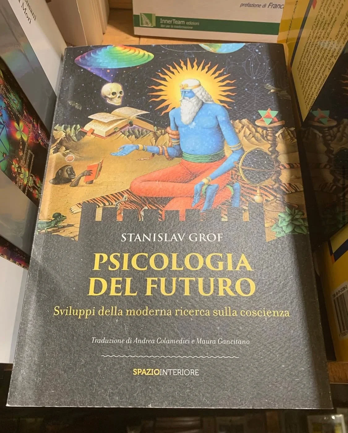 Libro titulado 'Psicologia del futuro' de Stanislav Grof, con ilustración psicodélica de una figura humana rodeada de elementos cósmicos y cómicos.