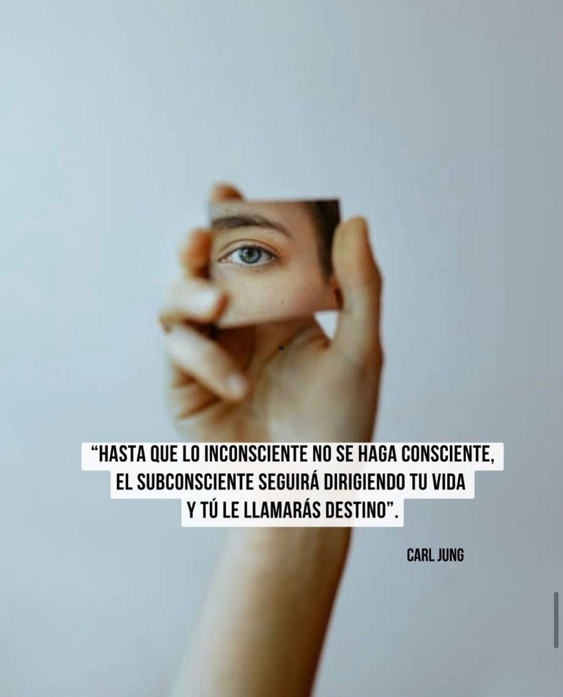 Persona sosteniendo un espejo pequeño que refleja solo su ojo y parte de su rostro. Sobre la imagen hay una cita en español que dice: "Hasta que lo inconsciente no se haga consciente, el subconsciente seguirá dirigiendo tu vida y tú le llamarás desti