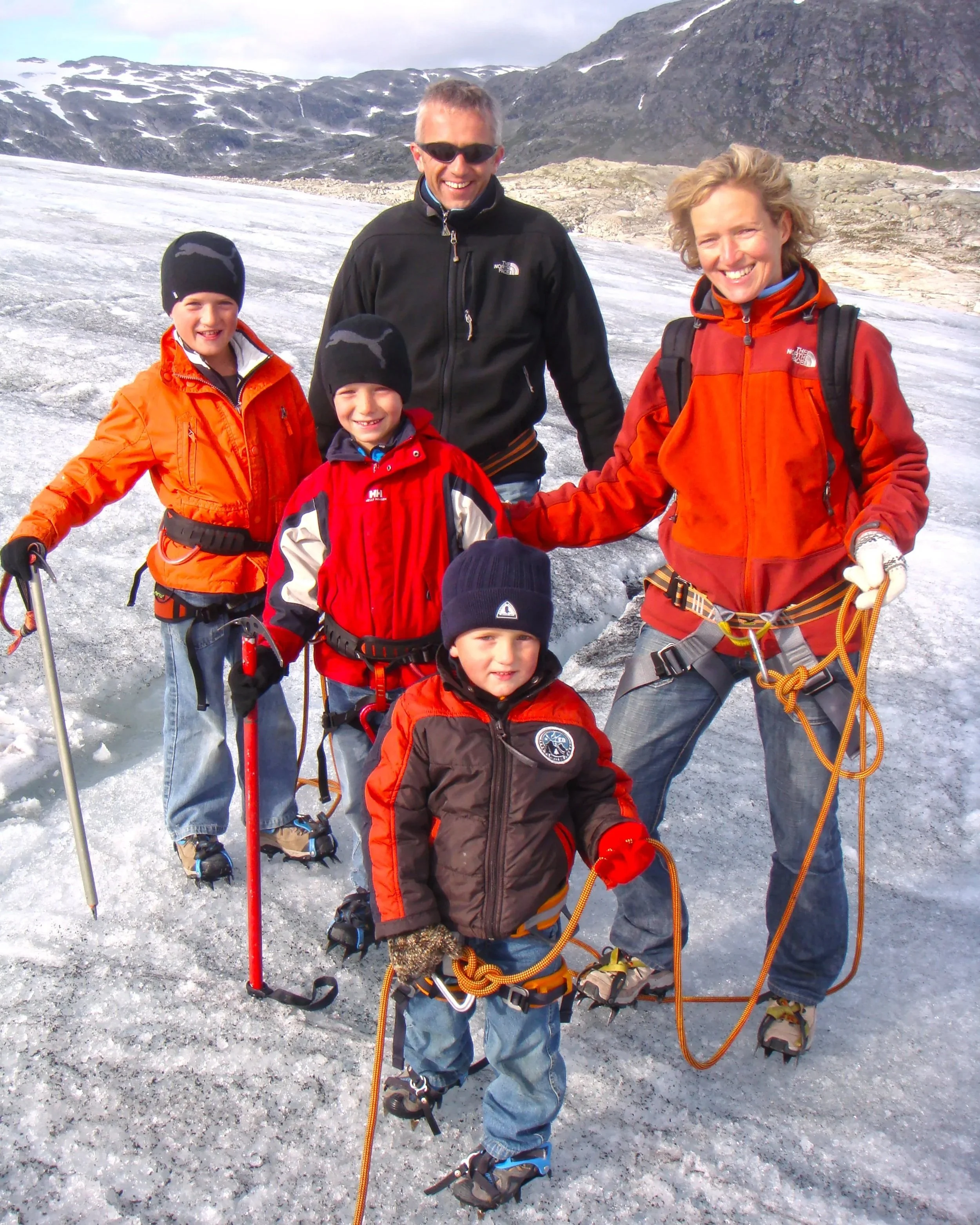 Family with young children roped together on a guided glacier hike in Jostedalsbreen National Park, Norway.