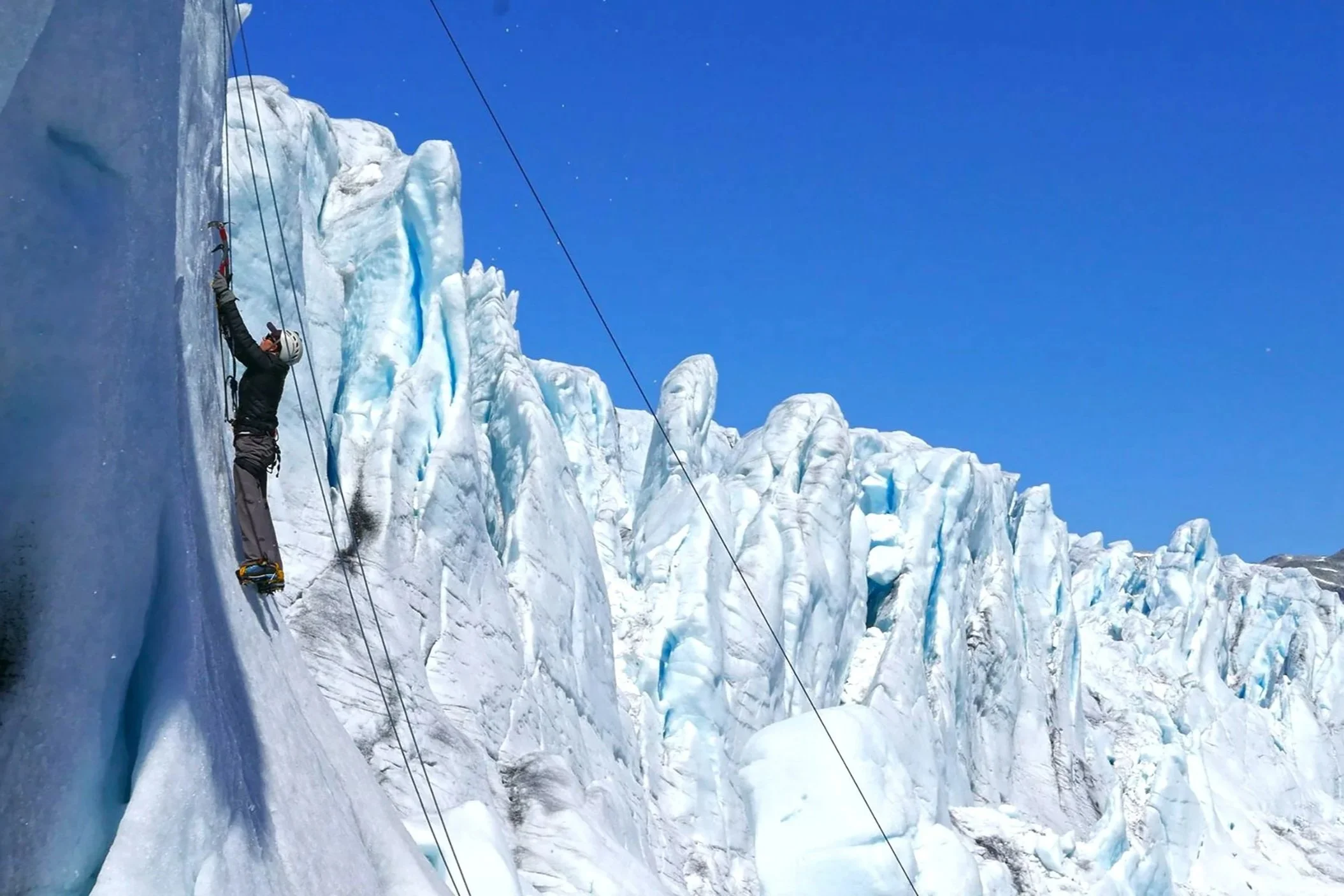 IJsklimmen op de Austdalsbreen met de indrukwekkende afkalvende gletsjerwand op de achtergrond in Nationaal Park Jostedalsbreen, Noorwegen.