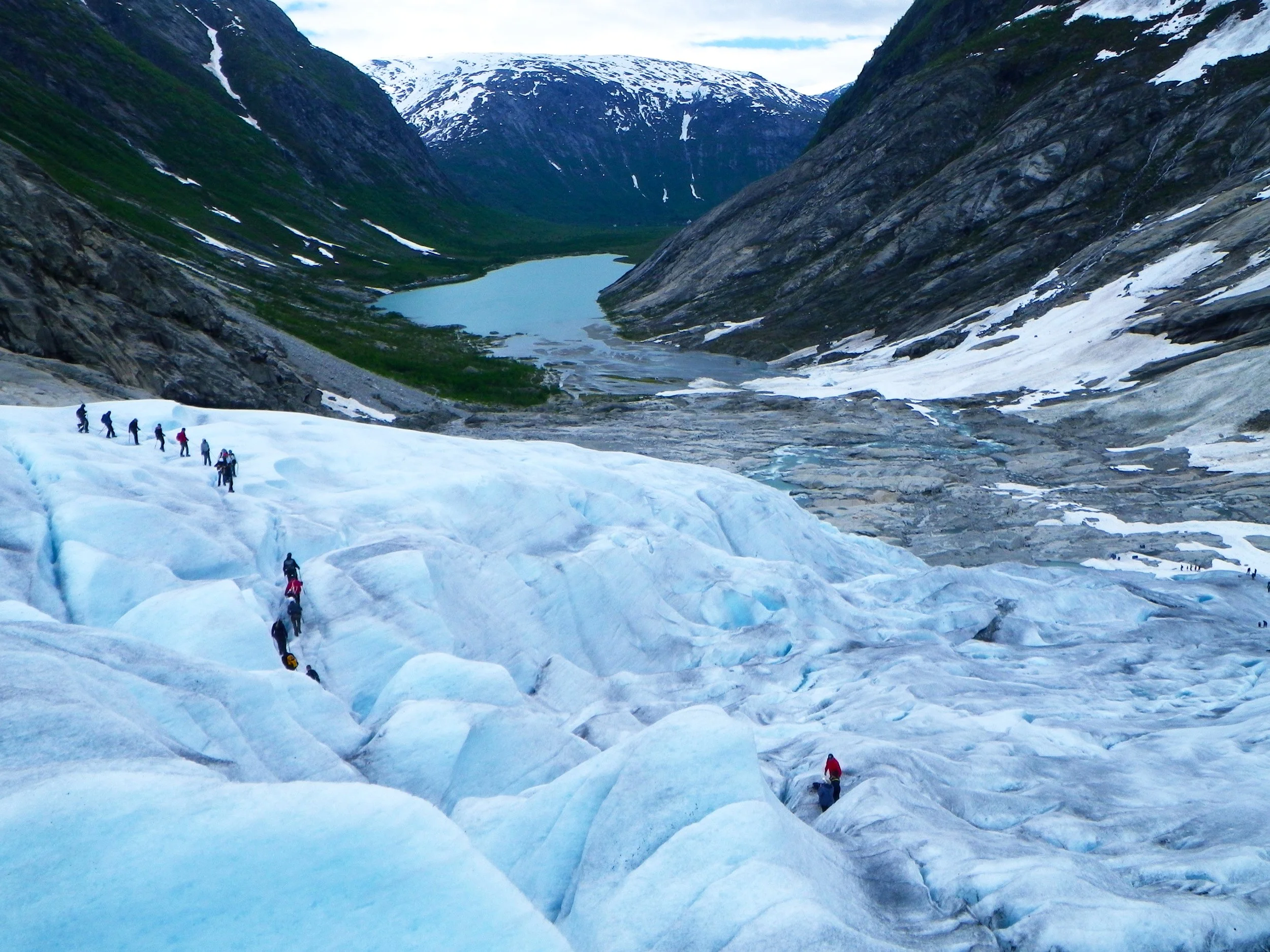 Guided glacier hiking group overlooking the valley and lake from Nigardsbreen in Jostedalsbreen National Park.