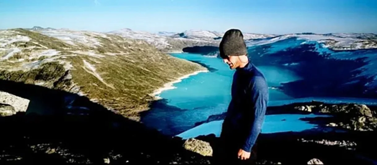 Gids die over het gletsjerplateau loopt met uitzicht op Styggevatnet in het avondlicht in Nationaal Park Jostedalsbreen, Noorwegen.