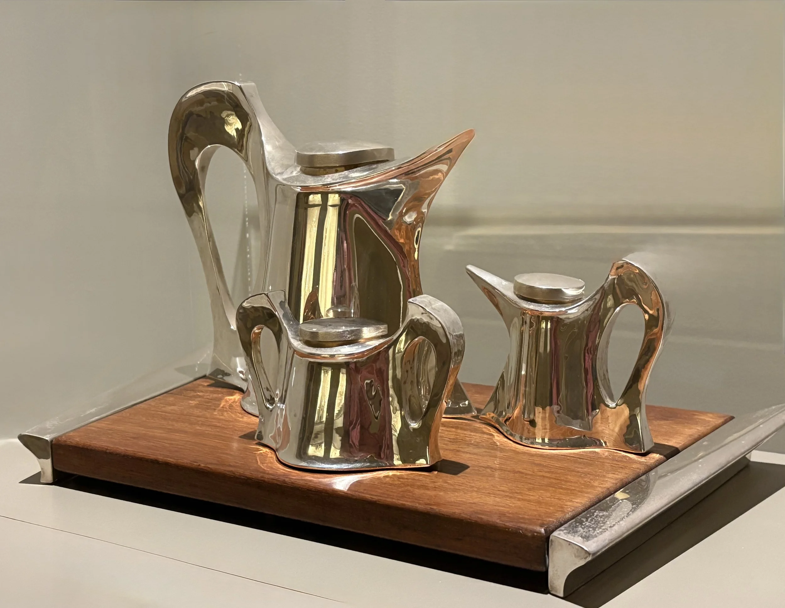 A sterling silver tea set with wood tray.
