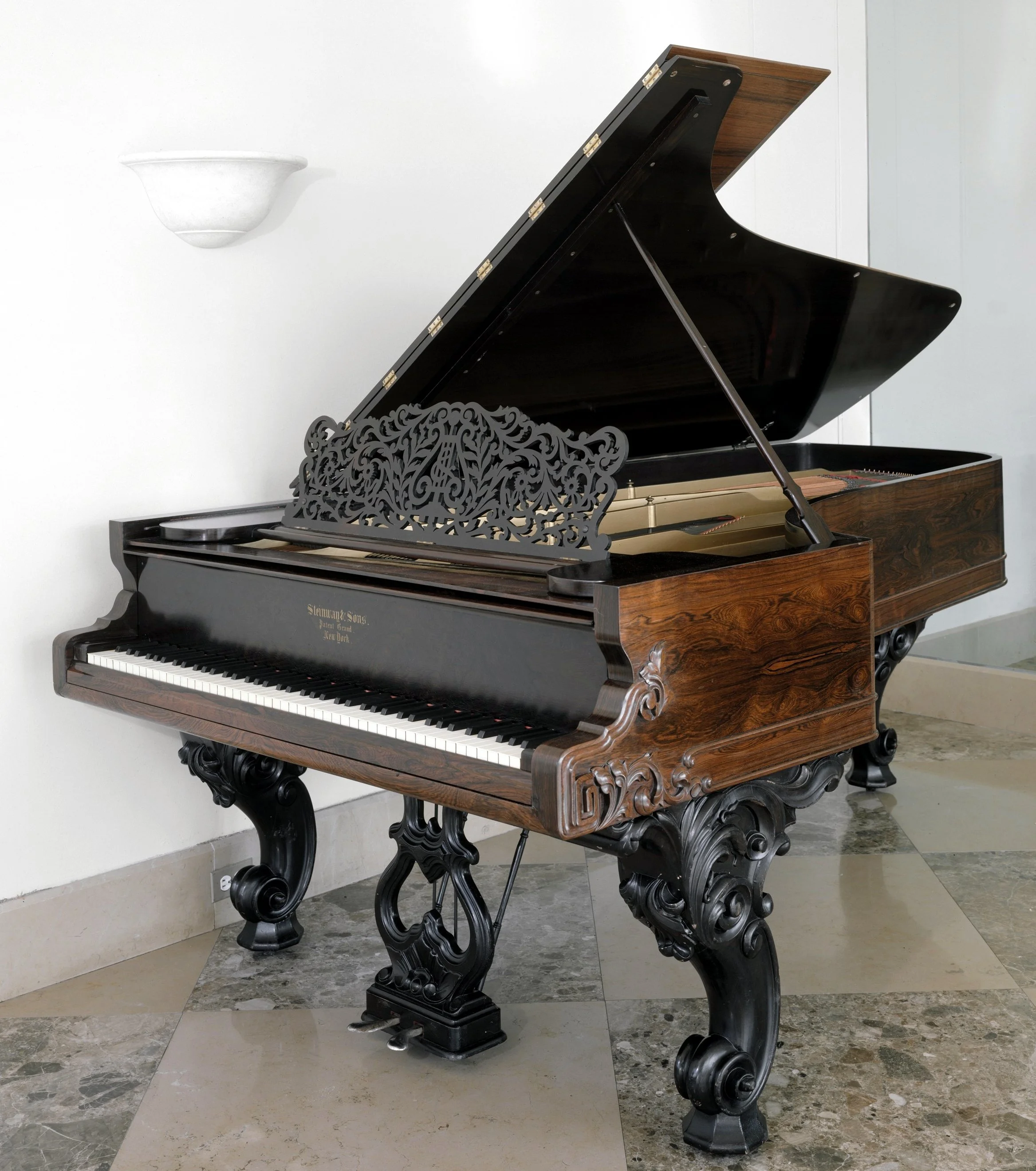An ornate Steinway art case grand piano with a black glossy finish