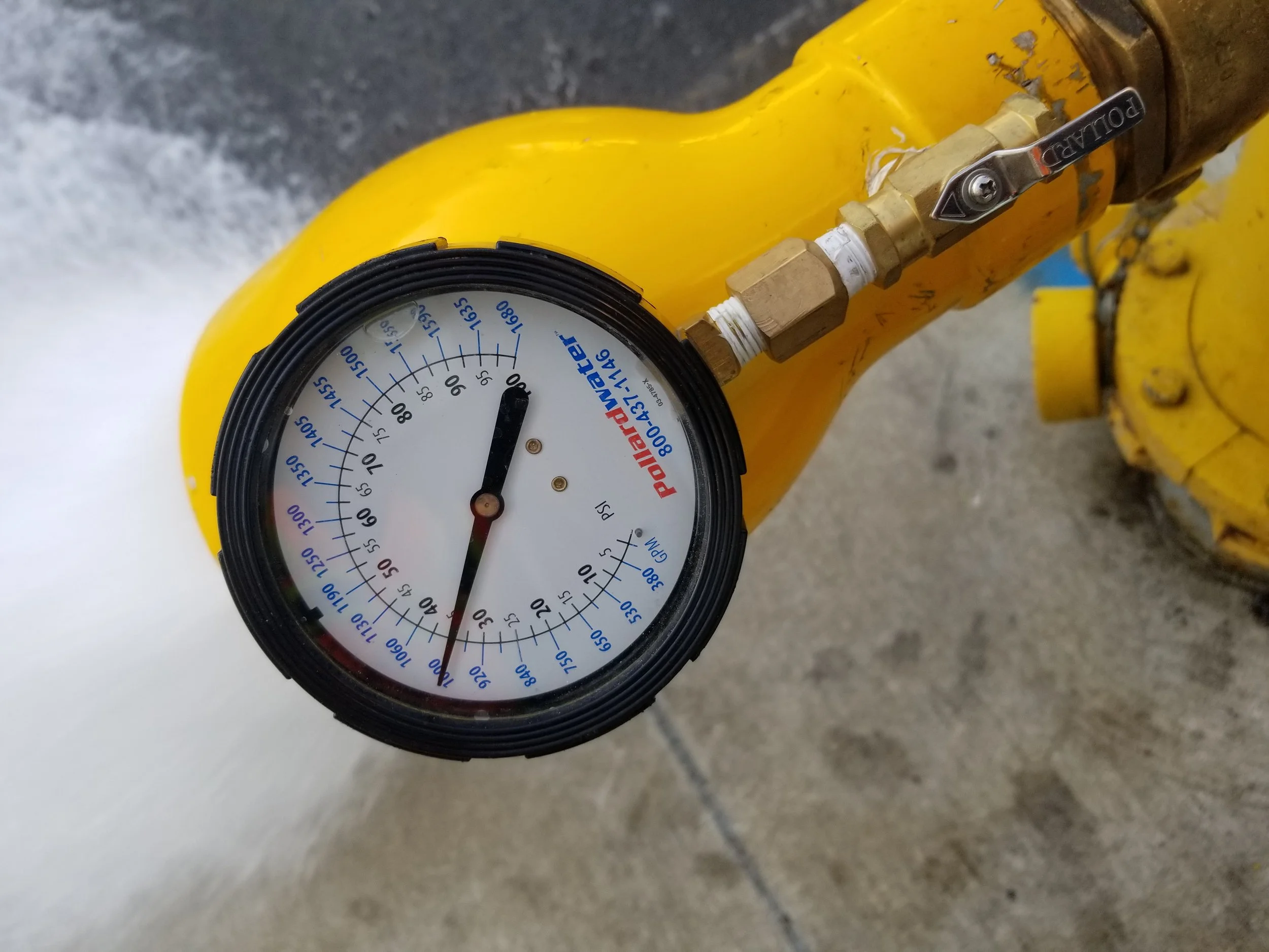 A yellow fire hydrant with a flow meter attached.