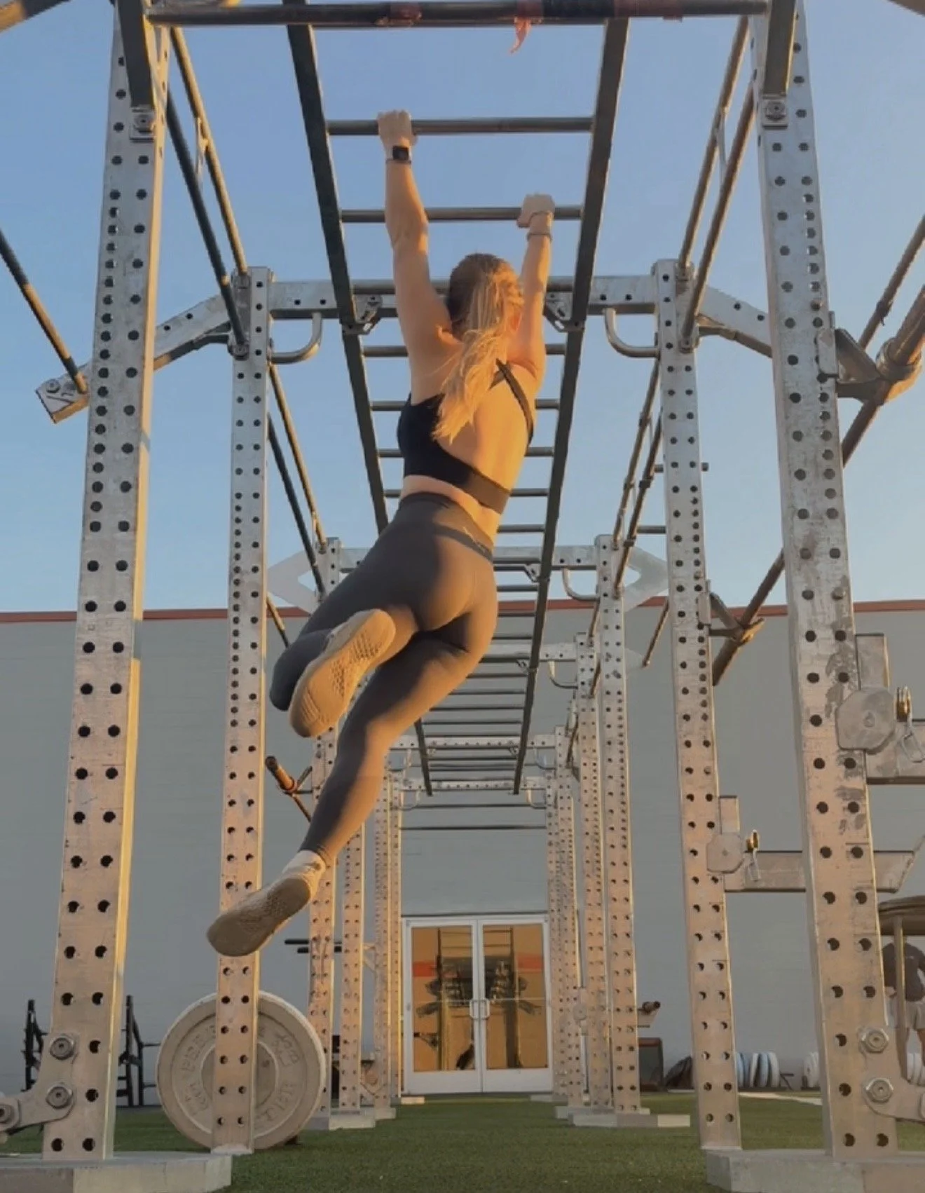 A woman in workout clothes doing strength training, performance rehabilitation, and working out in the gym space in Wilmington, NC.