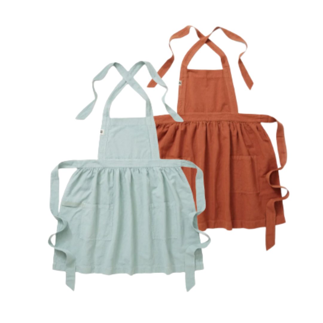 Two aprons, one in light blue and one in rust color, with neck straps and waist ties, hanging against a white background.