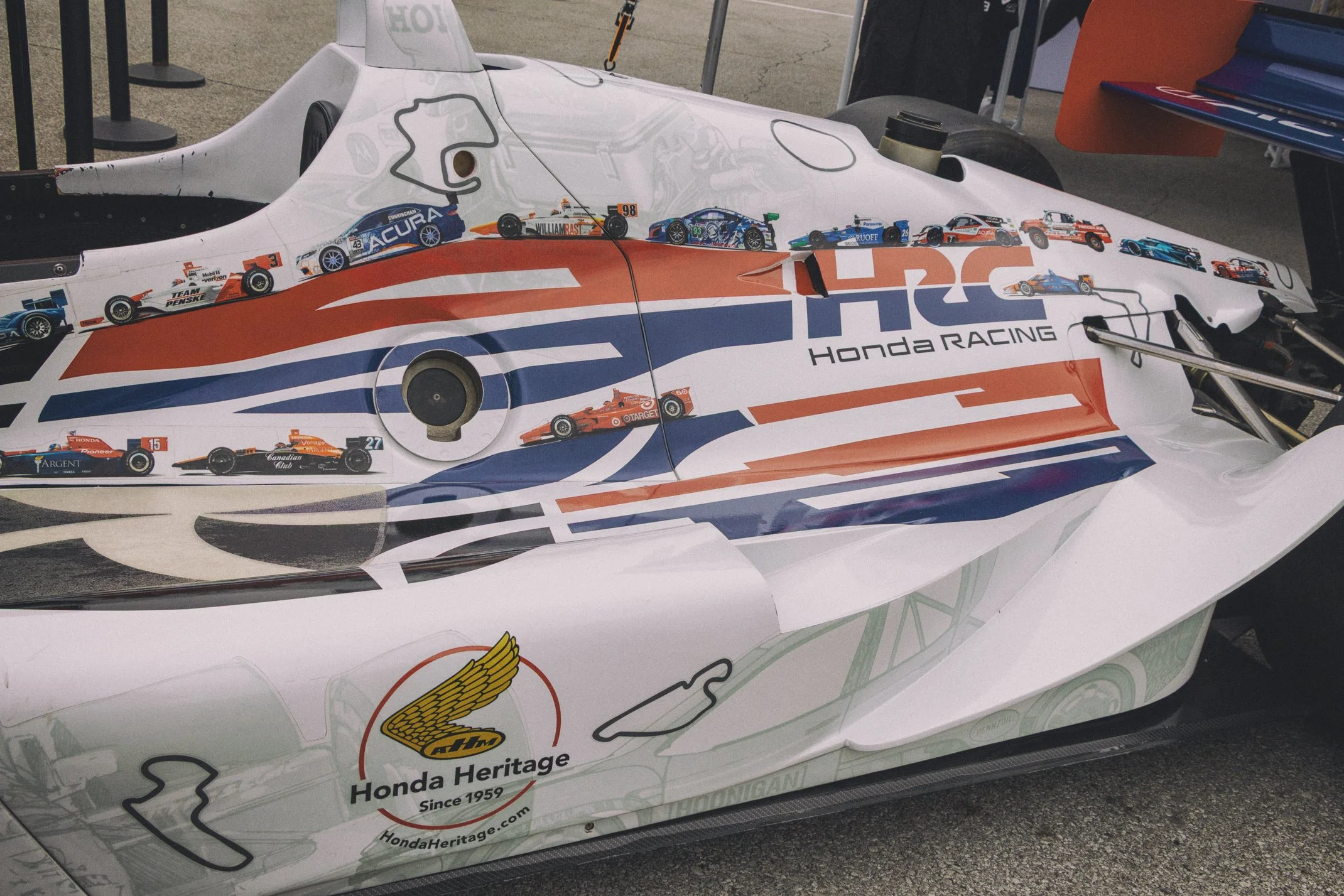 Close-up of a Honda IndyCar with a Richardson Racing livery, featuring various small race car illustrations and sponsor logos.