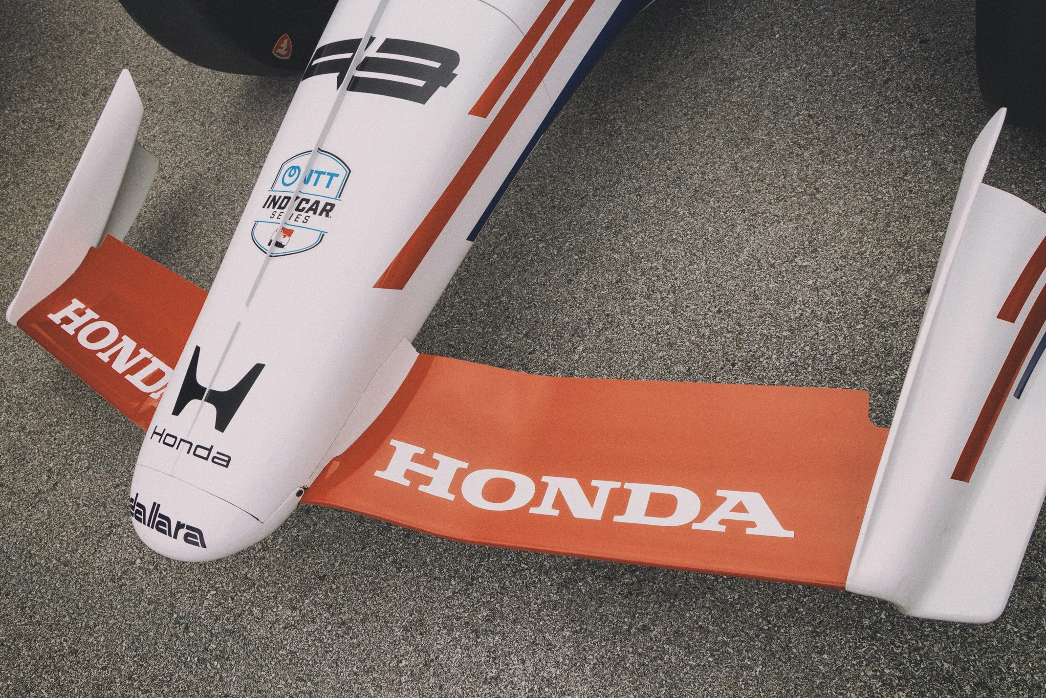 Multiple Honda flags and banners placed on a textured surface, displaying Honda and IndyCar Series logos and branding.