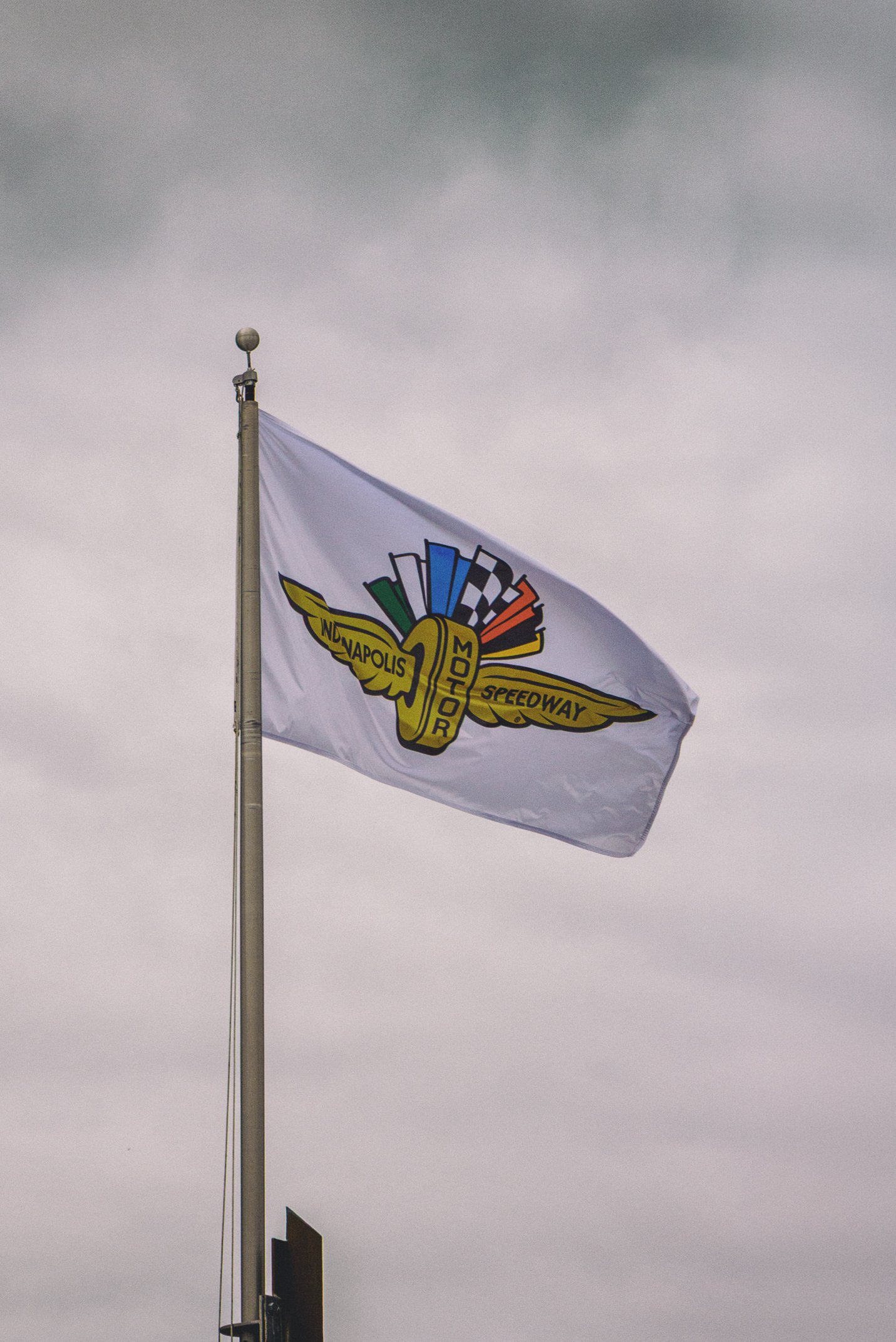 A flag with a Speedway logo flying against a cloudy sky.
