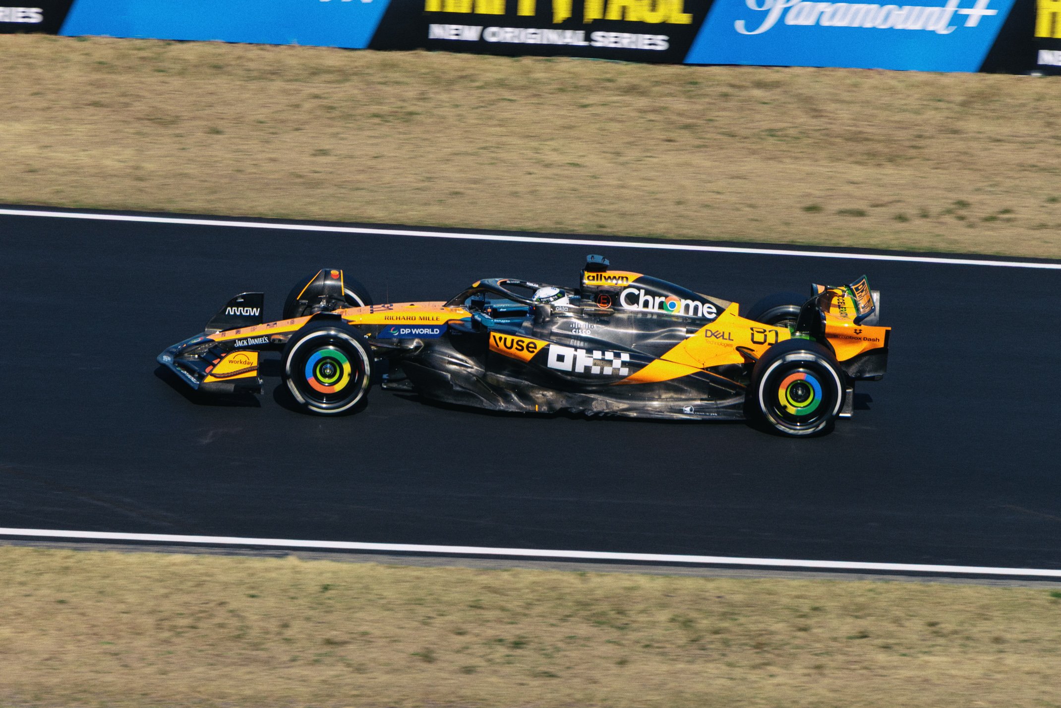 A yellow and black open-wheel race car driving on a race track.