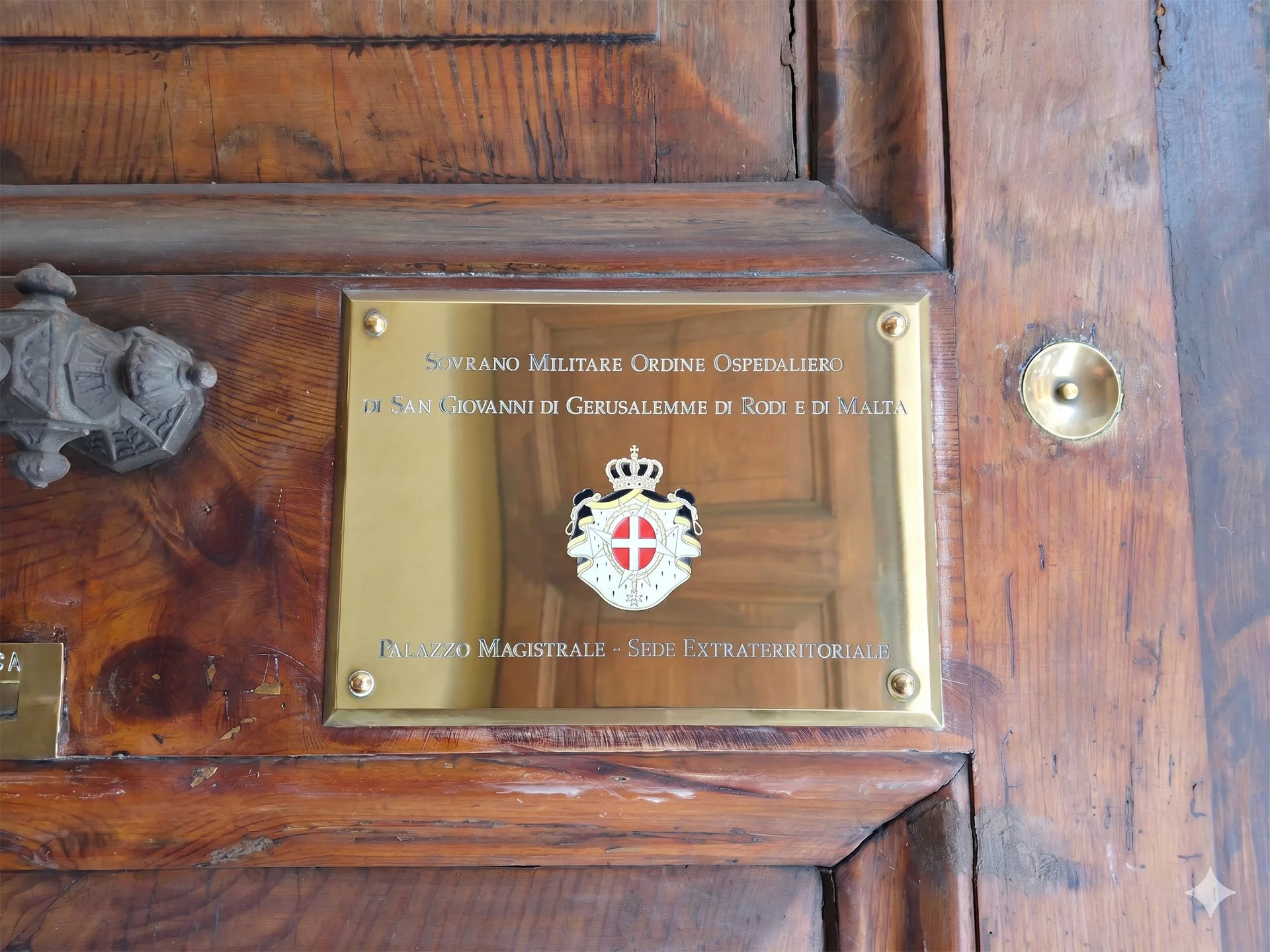 An official plaque marking the Sovereign Military Order of Malta's Magistral Palace on Via dei Condotti, near the Spanish Steps, Rome