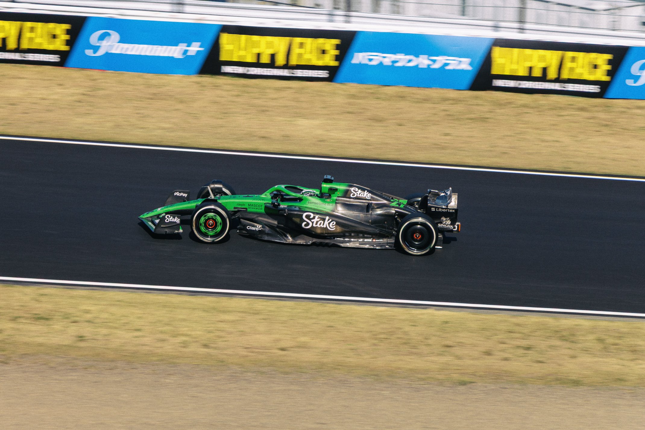 Race car on track with advertising banners in the background