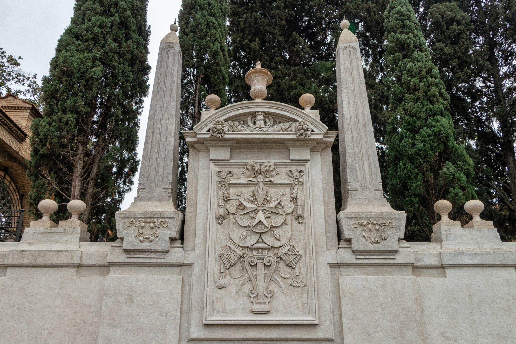 The Piranesi-designed stone wall surrounding Piazza dei Cavalieri di Malta on the Aventine Hill, Rome, decorated with military trophies and carved symbols of the Order of Malta