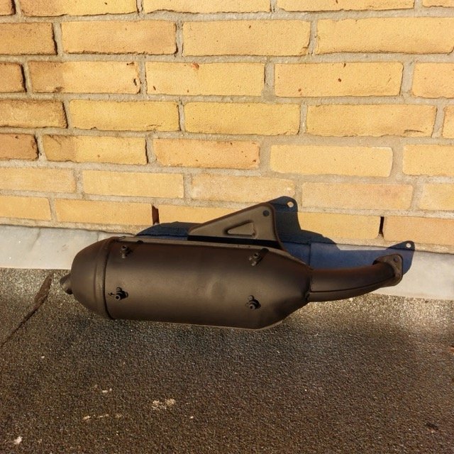 Uitlaat tegen bakstenen muur, gemonteerd op vloer.