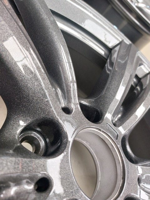 Close-up van een metalen velg met een glanzende afwerking.
