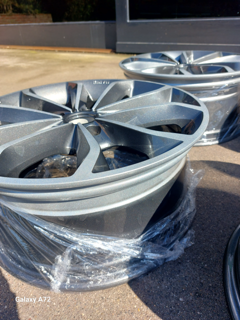Grijze lichtmetalen velgen op plastic verpakkingen buiten opgesteld.