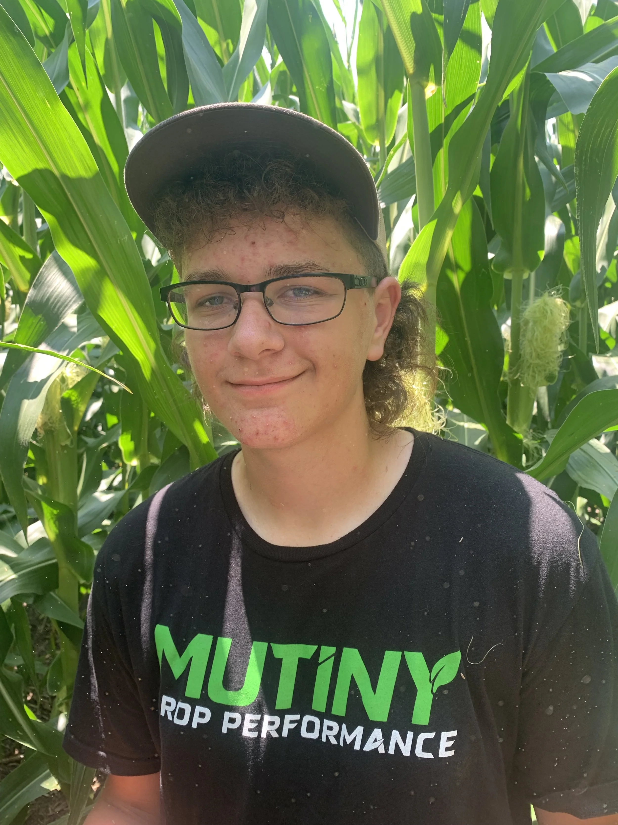 James Reid, poses for a picture in a corn field in a black mutiny crop performance t shirt