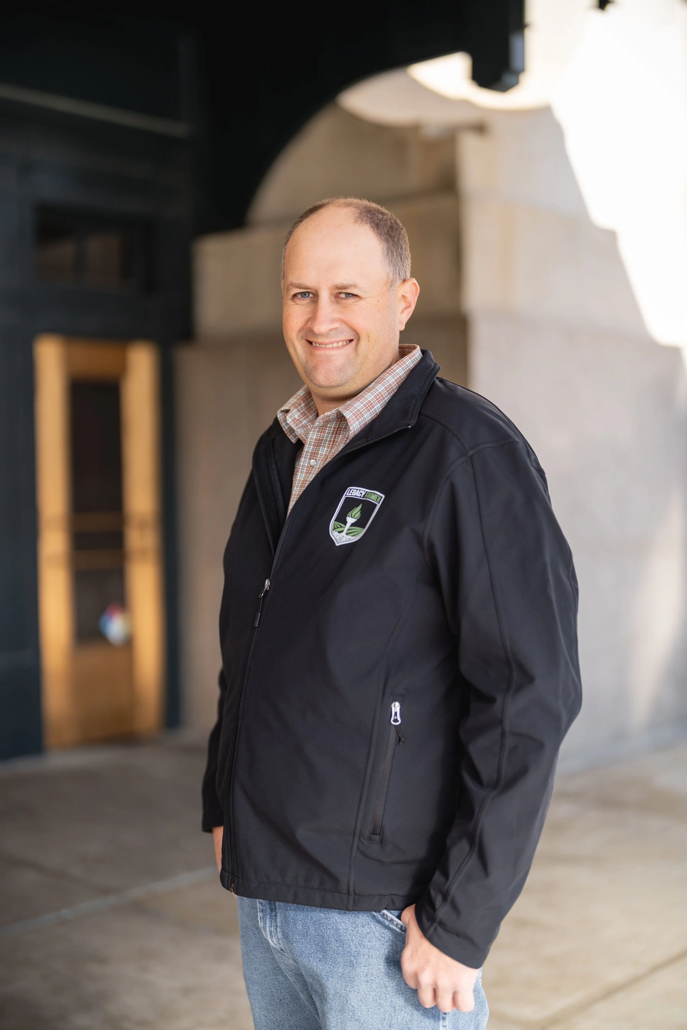 Brooks Reid, an agronomist, stands for a headshot whie wearing a black jacket.