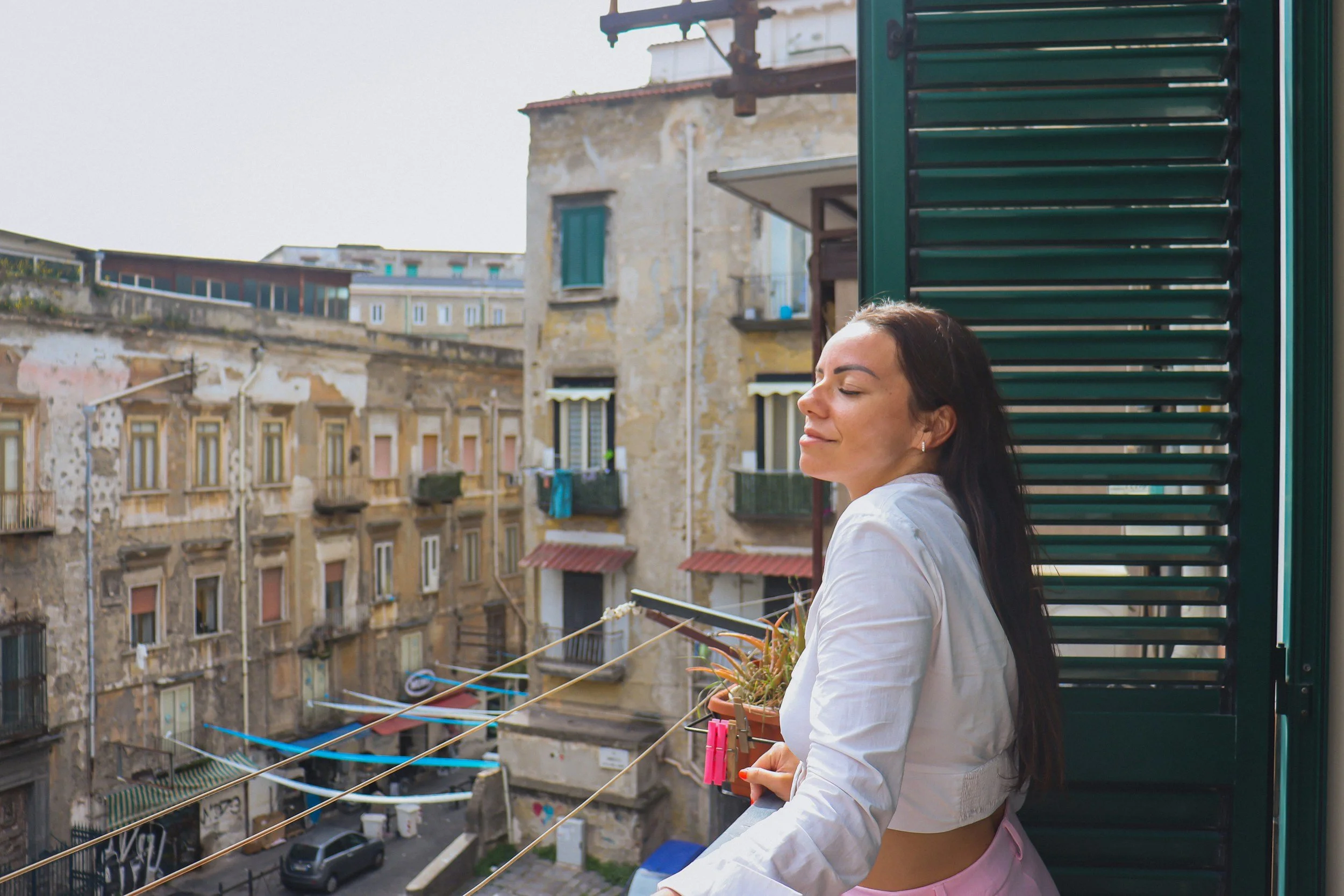 Woman relaxing on a sunny balcony with a cup of tea