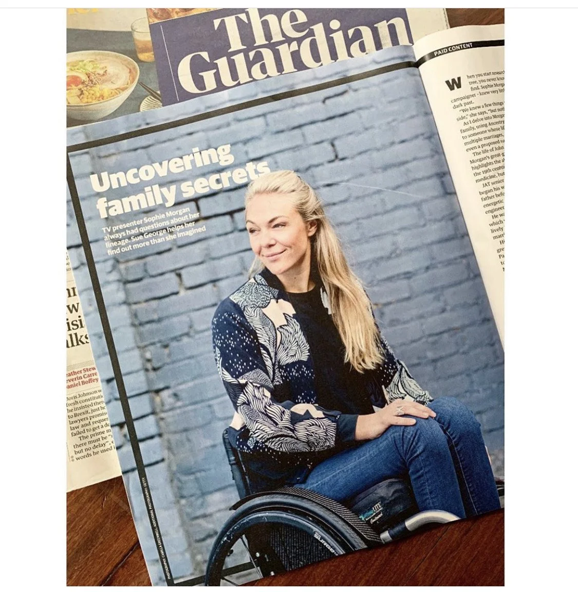 Magazine article featuring a woman in a wheelchair sitting against a blue brick wall, with the headline "Uncovering family secrets" and text about TV presenter Sophie Morgan.
