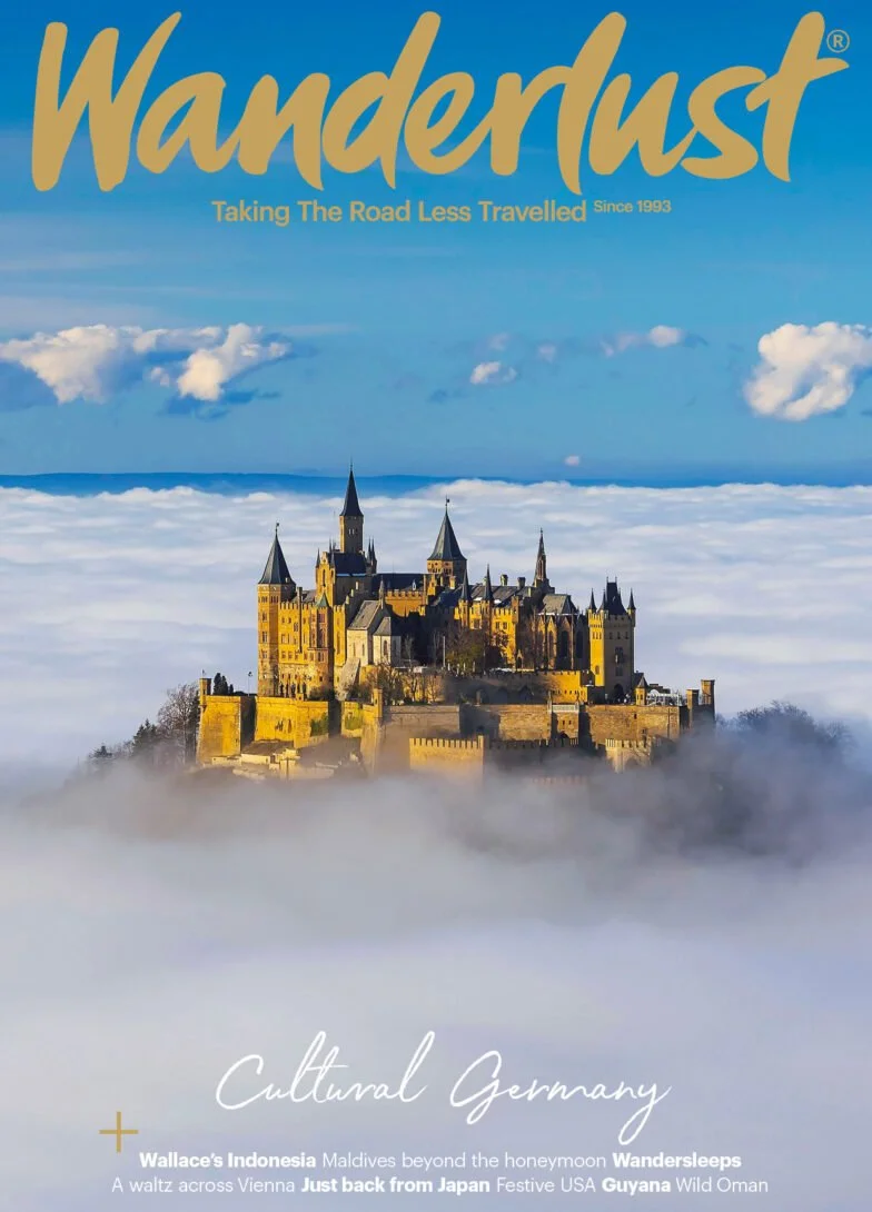 Cover of Wanderlust magazine featuring Neuschwanstein Castle in Germany surrounded by clouds, with the title and various travel headlines.