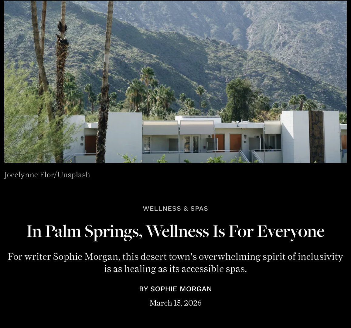 Modern white building with desert mountain background and palm trees in Palm Springs.