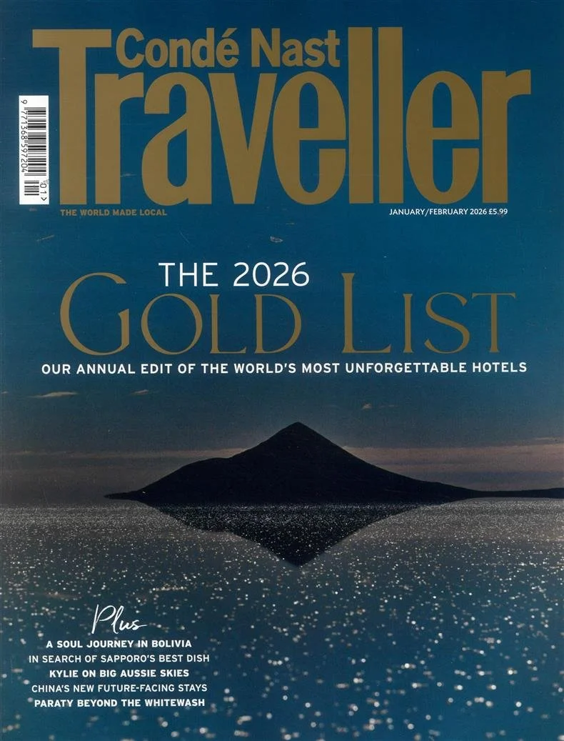 Aerial view of a street scene in New Orleans featuring a red streetcar on tram tracks surrounded by palm trees and pedestrians.