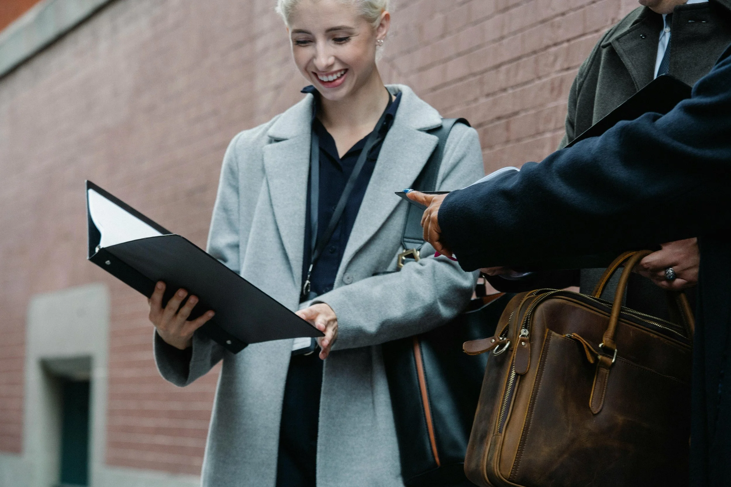 A smiling woman looking down at a document while outdoors, appearing happy and satisfied. The image represents a smooth and successful apostille process, conveying confidence, relief, and ease.