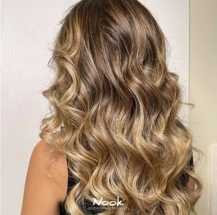 Cheveux longs, bouclés et ombré, passant du châtain clair au blond