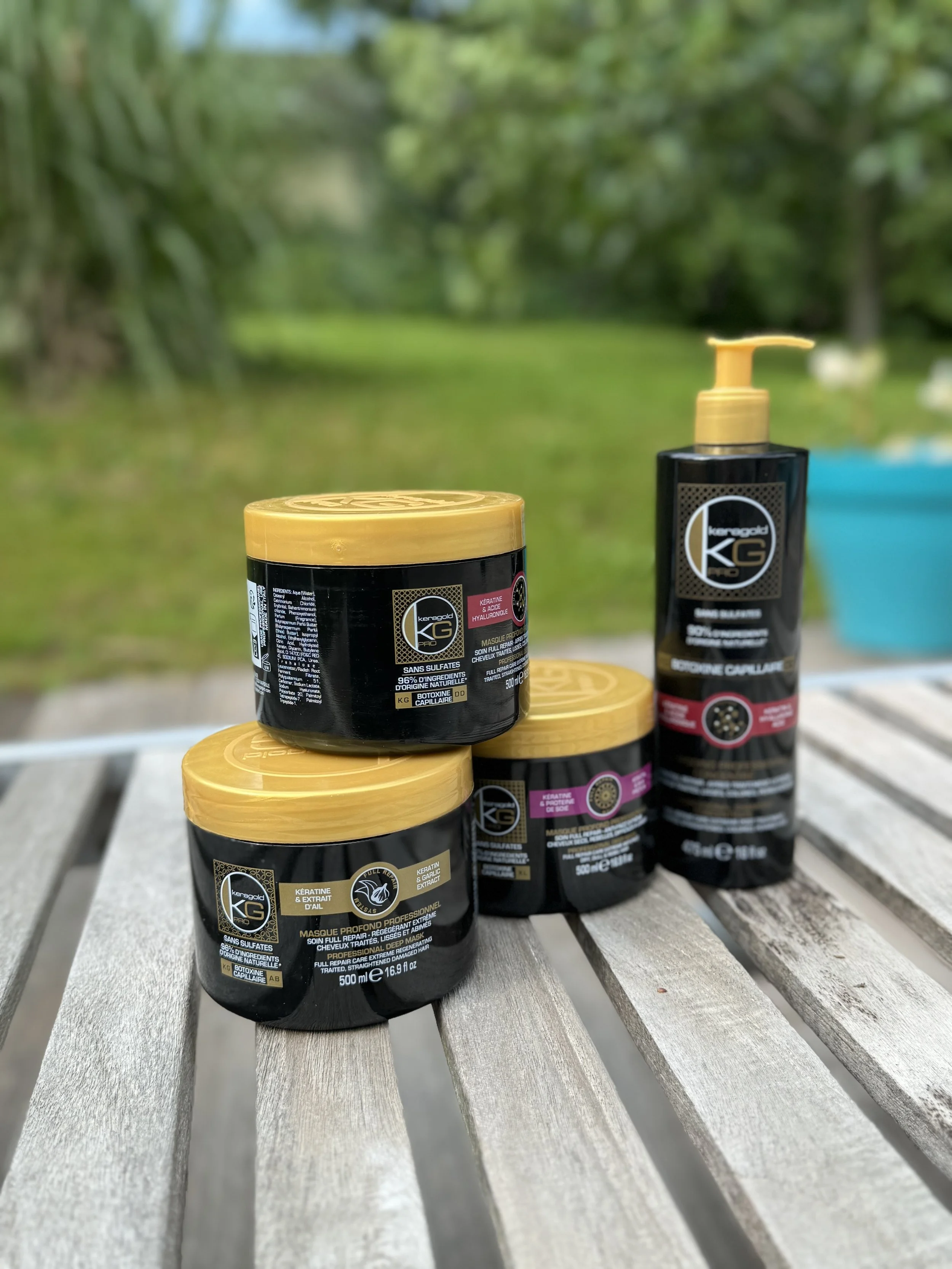 Boutique de produits capillaires noirs avec des couvercles jaunes, affichés sur une table en bois à l'extérieur.