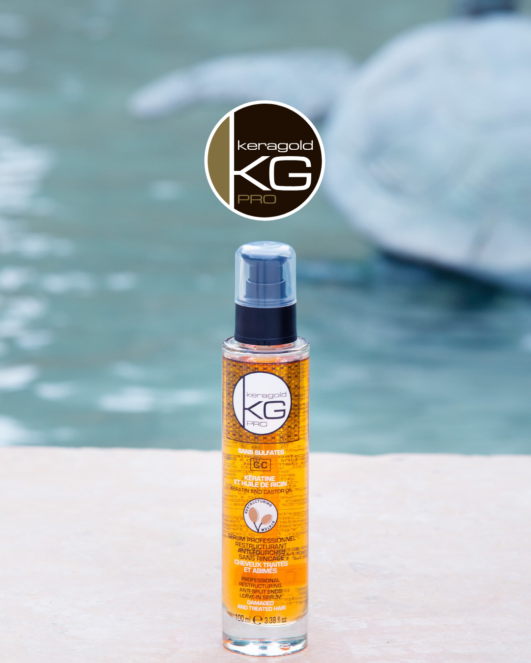 Flacon de soin capillaire à l'huile de ricin avec étiquetage orange, placé devant une piscine ou un fond d'eau bleue, vue de face.