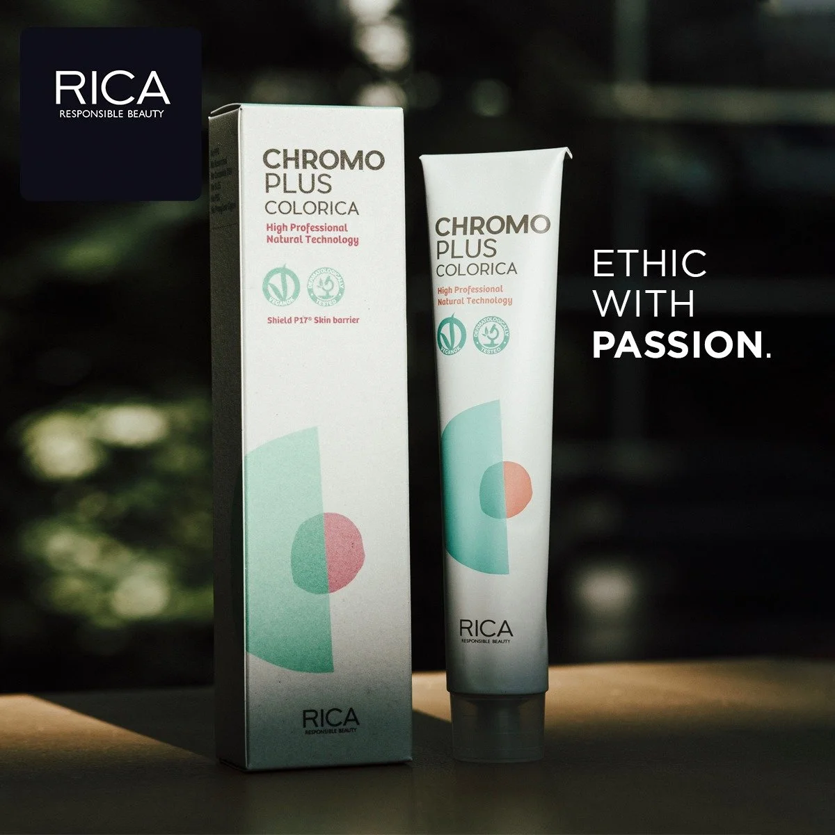 Une boîte et un tube de crème de la marque Rica, modèle Chromo Plus Colorica, avec des logos écologiques, sur fond sombre avec lumière naturelle, accompagnés du texte 'Éthique avec passion'.