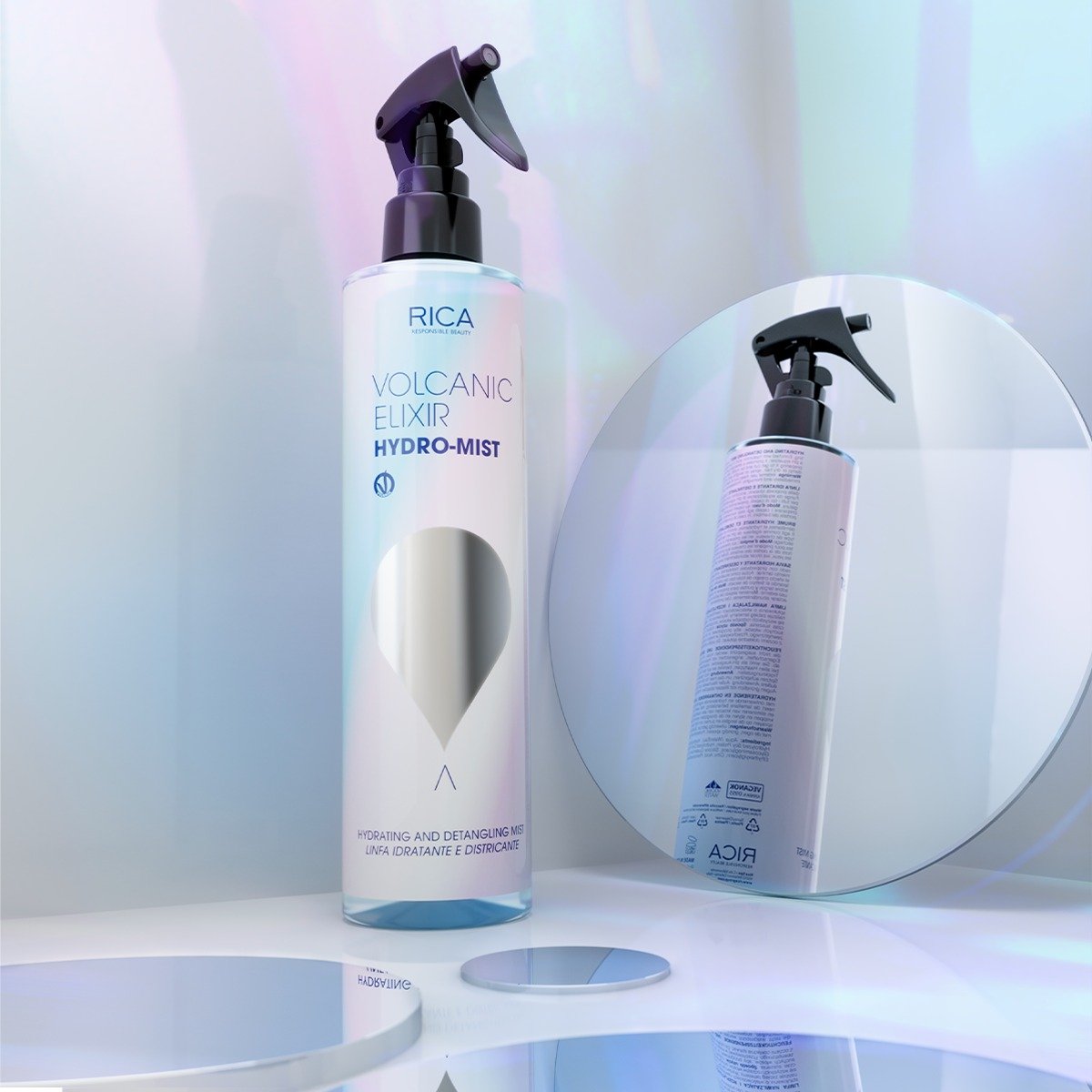 Une bouteille de brume hydratante et démêlante RICA Volcanic Elixir Hydro-Mist est placée devant un miroir rond."