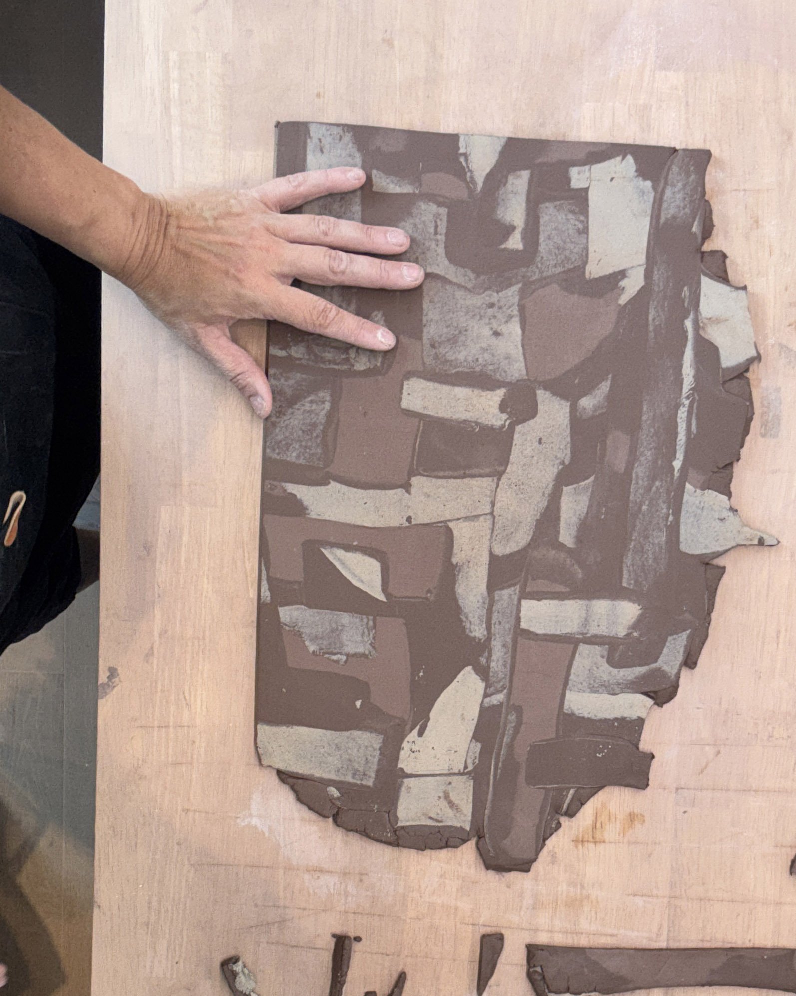 The pieces are pressed and rolled together into a continuous patterned slab.