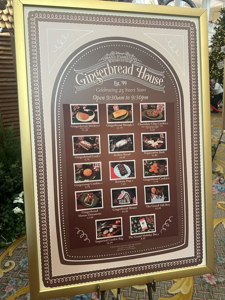 Signboard for Gingerbread House at Disney's Grand Floridian Resort & Spa, celebrating 25 years, open from 9:30 am to 9:30 pm. The sign features images and prices of various gingerbread treats and decorations, including gingerbread Mickey, shingle, ch
